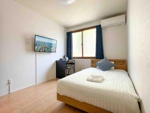 a bedroom with a bed and a desk in it at D旅館　Dryokan in Tokyo