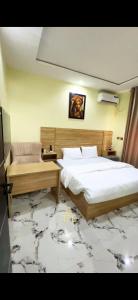 a bedroom with a large bed and a table at TFE Apartments in Ibadan +8 photos
