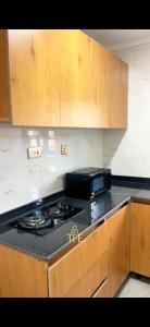 a kitchen with a stove and a microwave at TFE Apartments in Ibadan