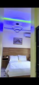 a bedroom with a large bed with a purple ceiling at TFE Apartments in Ibadan