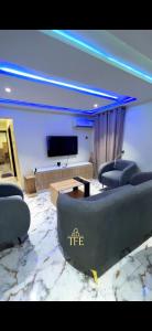 a living room with couches and a flat screen tv at TFE Apartments in Ibadan