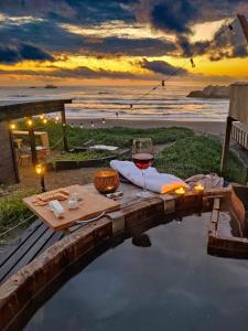 a glass of wine sitting on a table next to the ocean at Tinaja en la playa para 2 in Matanzas +23 photos