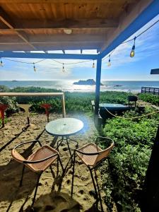 a patio with a table and chairs on the beach at Tinaja en la playa para 2 in Matanzas