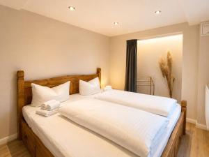 a bedroom with a large bed with white sheets at Ferienwohnung Resi´s Welfenoase in Schwangau
