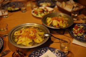 a table with two bowls of food and plates of food at La Source Desert Camp in Adrouine