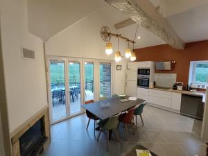 a kitchen and dining room with a table and a fireplace at La Grange de Céor in Cassagnes-Bégonhès