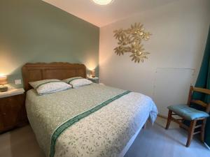 a bedroom with a bed and a blue chair at La Grange de Céor in Cassagnes-Bégonhès