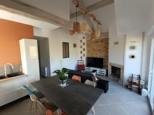 a dining room and living room with a table and a couch at La Grange de Céor in Cassagnes-Bégonhès