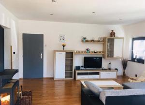 a living room with a couch and a tv at Bungalov pod Lípami in Mladějov