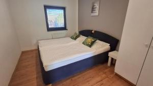 a small bed in a small room with a window at Bungalov pod Lípami in Mladějov