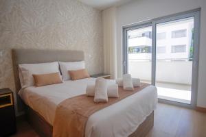 a bedroom with a large white bed with a window at Rooftop pool & Luxury apartment in Lagos +19 photos