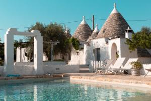 a house with a swimming pool in front of it at Trullo Picchiagiuda in Ostuni