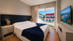 a hotel room with a bed and a large window at Ingleses Holiday Studios in Florianópolis +42 photos