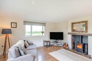 a living room with a fireplace and a tv at 3 Bed in Belford oc-79178 in Belford