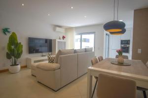 a living room with a white couch and a table at Rooftop pool & Luxury apartment in Lagos
