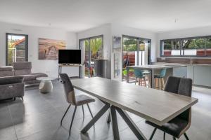 a kitchen and living room with a wooden table and chairs at violette in Pornichet