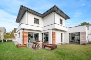 a white house with a black roof at violette in Pornichet