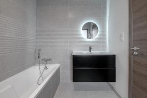 a bathroom with a tub and a sink and a mirror at violette in Pornichet