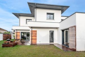 a white house with a black roof at violette in Pornichet