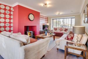 a living room with white furniture and a red wall at 5 Bed in Seahouses oc-nb621 in Seahouses