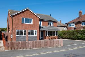 a brick house with a wooden fence in front of it at 5 Bed in Seahouses oc-nb621 in Seahouses
