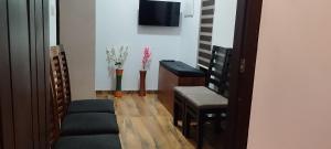 a living room with chairs and a tv on a wall at Dune Hostel - Dune Homestay in Alleppey