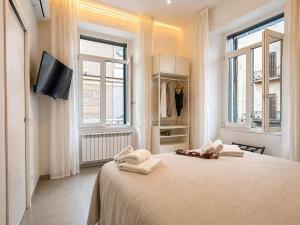 a white bedroom with a bed with towels on it at iPrincipati Luxury Living Suite in Salerno
