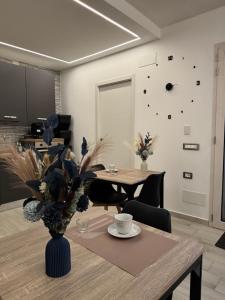 a dining room with a table with a vase of flowers at Aura Maris in Guspini