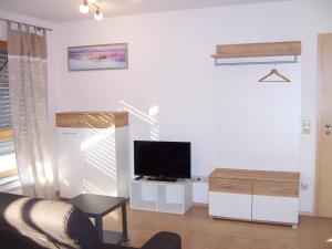 a living room with a flat screen tv on a wall at Ferienwohnung Störkle in Maselheim