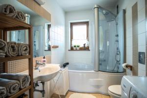 a bathroom with a tub and a sink at 4U Apartments - Zakopane in Zakopane