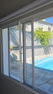 a window with a view of a swimming pool at Vida & Brisa Pousada in Pelotas