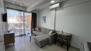 a living room with a couch and a table at Bella Luxury Suite III in Paralia Katerinis