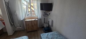 a room with a tv on the wall and a window at Apartament Nova Kamienica 1 in Łagów