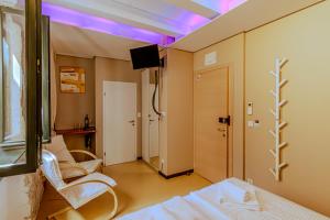 a room with a bed and a tv on a ceiling at Tre Porte Rooms & Bar in Rovinj