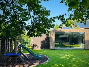 a playground in a yard with a slide at Het Huis - luxury villa near Tomorrowland in Willebroek