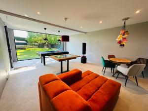 a living room with a couch and a pool table at Het Huis - luxury villa near Tomorrowland in Willebroek