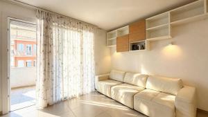 a living room with a white couch and a large window at Marco Polo House in Chioggia