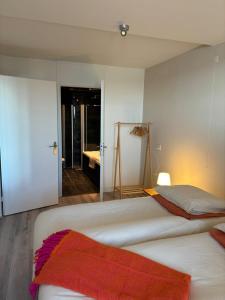 a bedroom with two beds and a mirror at Strandappartement Iselmar Makkum nr 30 in Makkum