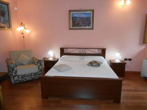 a bedroom with a bed and a chair and lights at I QuattroGioielli in SantʼAngelo le Fratte