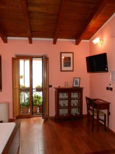 a living room with pink walls and a wooden ceiling at I QuattroGioielli in SantʼAngelo le Fratte