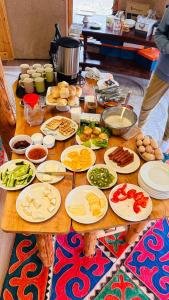 a wooden table with plates of food on it at Altyn Oimok Yurt Camp in Tong