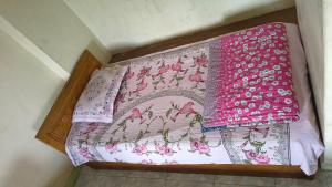 a bed with a pink and white blanket on it at Pauro Abashik Hotel in Khagrāchari