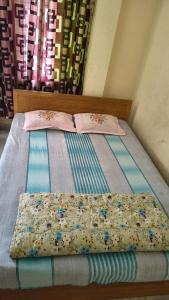 a bed with two pillows on top of it at Pauro Abashik Hotel in Khagrāchari