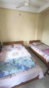 two beds sitting next to each other in a room at Pauro Abashik Hotel in Khagrāchari