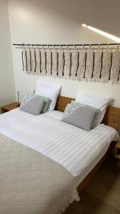 a bedroom with a bed with white sheets and pillows at Studios & Appartements famille - Saillon Evasion in Saillon