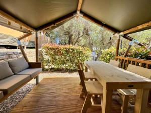 a wooden table and bench on a wooden deck at Camper Village in Santo Stefano al Mare
