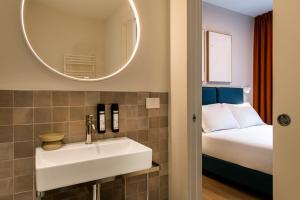 a bathroom with a sink and a bed at RELSTAY - Vercelli Suites in Milan +26 photos