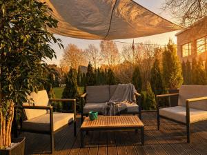 a patio with two chairs and a table on a deck at Casa Luba in Saulkrasti