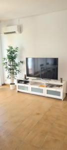 a living room with a large flat screen tv at Villa Orchidée - Coves Noves in Punta Grossa