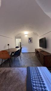 a room with a table and a television and a bed at Residence by Talking Stones in Dolceacqua